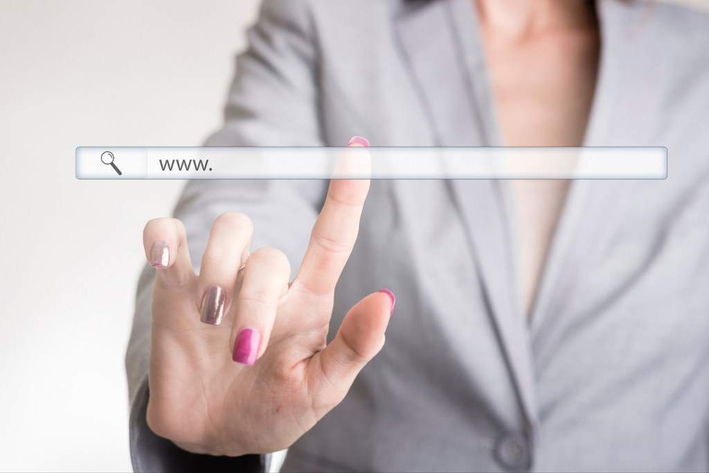 Female Hand Touching a Website Navigation Bar.
