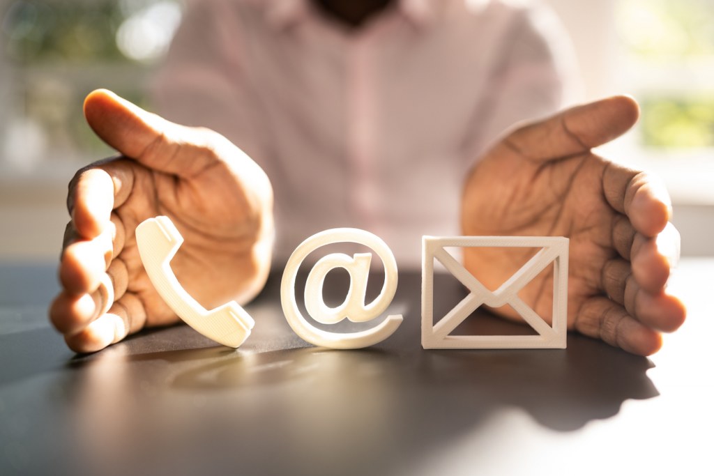 Hands on side covering Contact US icons.