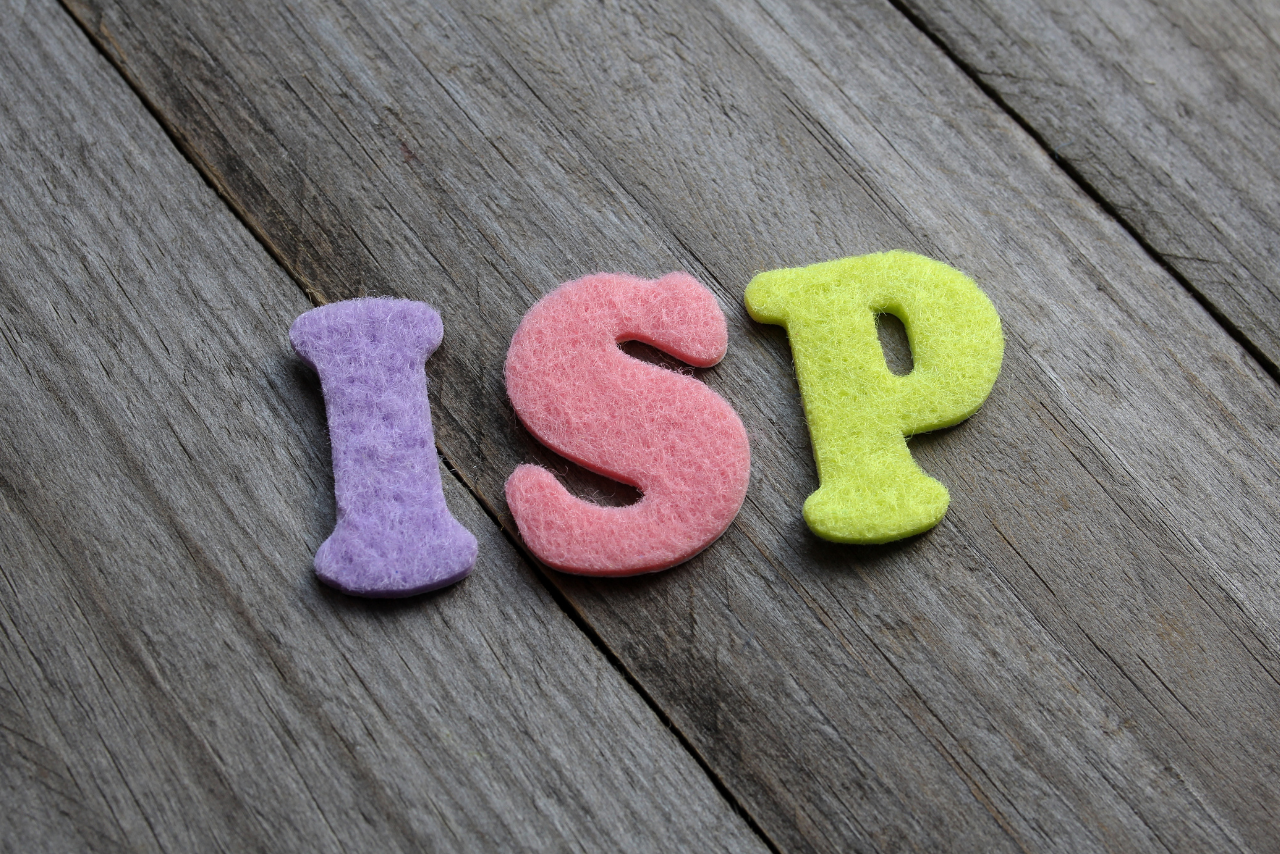 ISP acronym on wooden background.