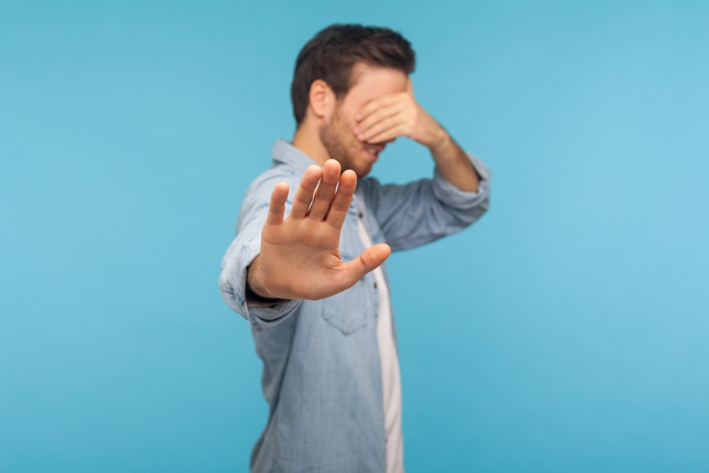 Man Covering Eyes ignore Stop Gesture.