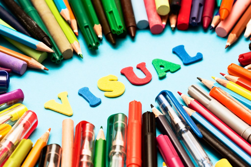 VISUAL say play letters surrounded by drawing materials.