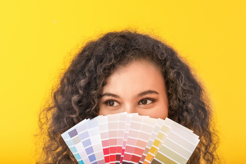 Woman covering mouth with color palettes.