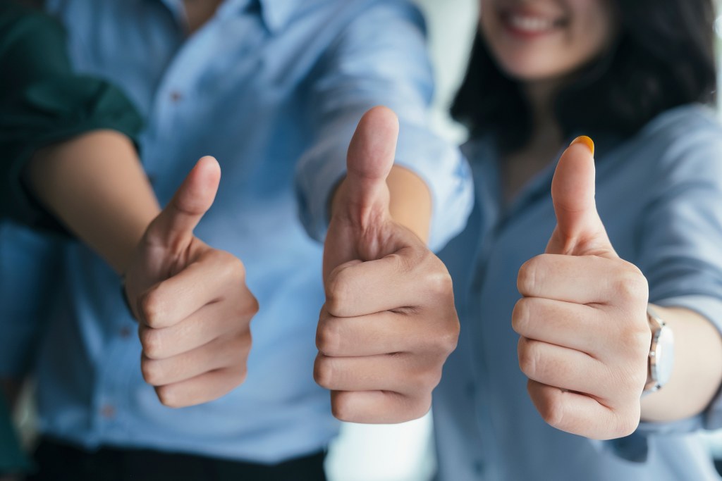 Business People Giving Thumbs Up Gesture showing approval.