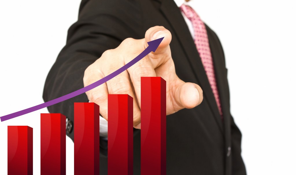 A man pointing at a graph with a rising trend.