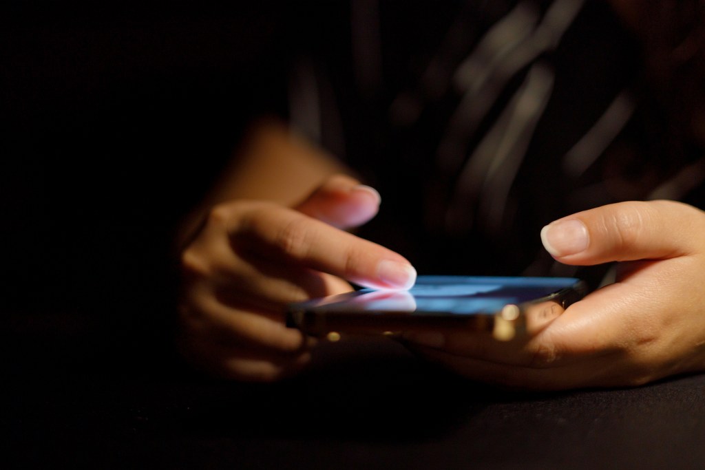 Person scrolling on phone.