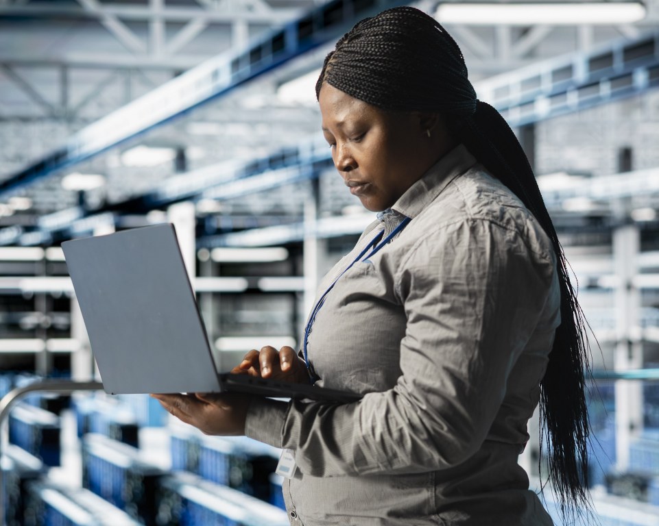 A woman troubleshooting network issues in a data centre.