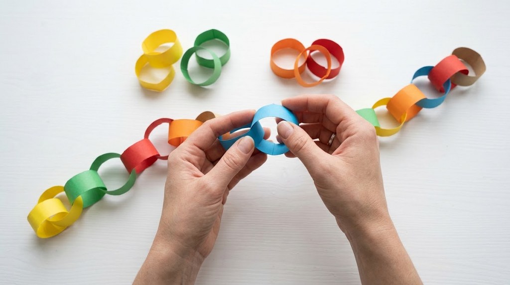 Hands creating a colorful paper chain