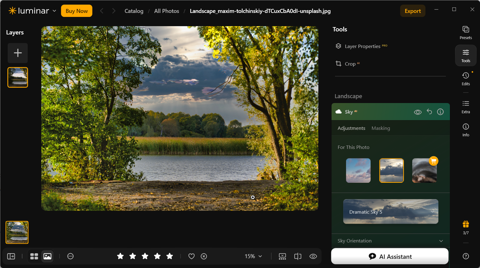 Lake landscape in Luminar Neo after selecting Dramatic Sky 5, showing dark layered clouds behind trees and bright sunlit foliage in the foreground.