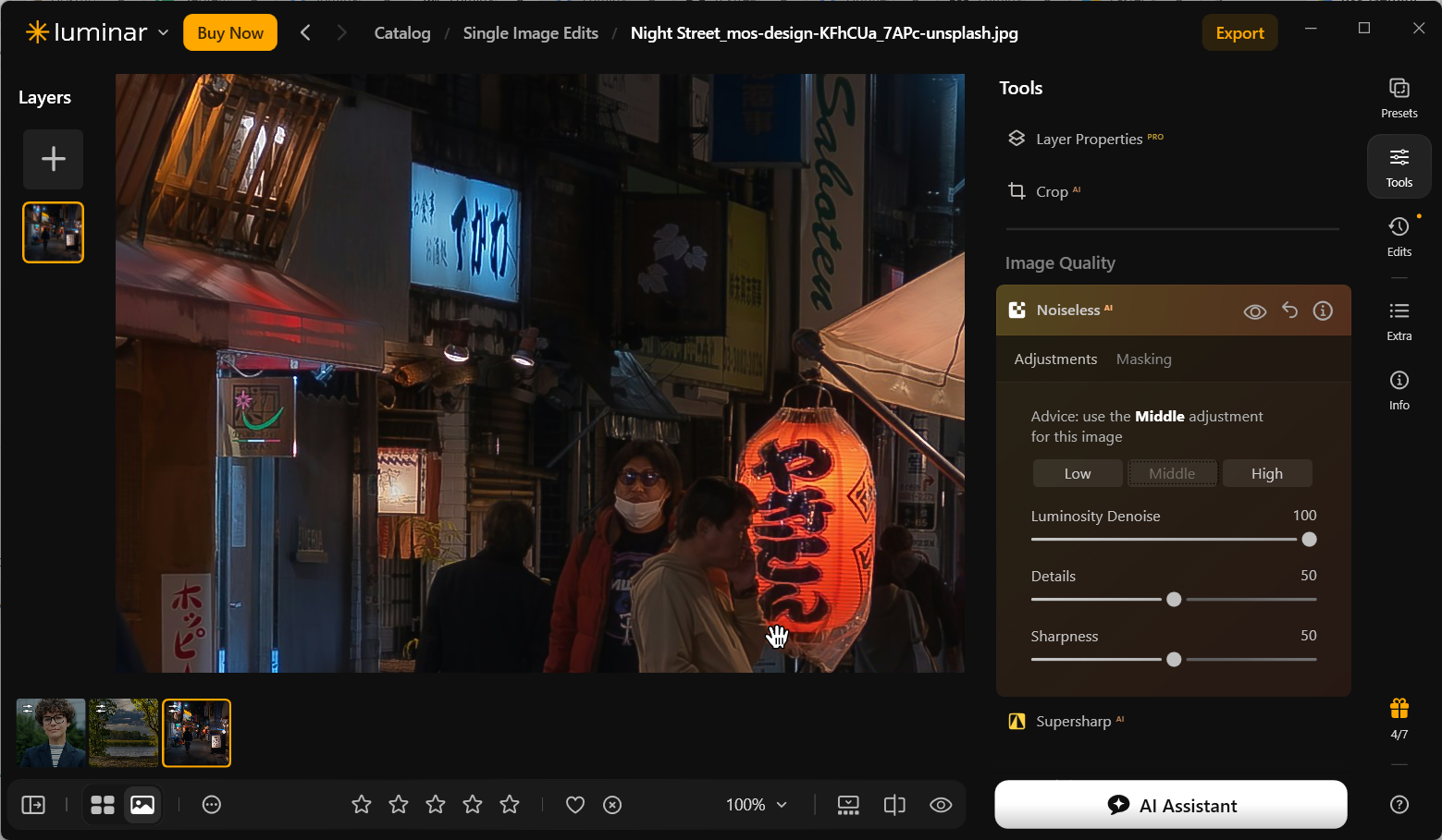 Night street photograph displayed at 100% in Luminar Neo after the Middle Noiseless AI adjustment, with the bright orange lantern and small storefront signs visible.
